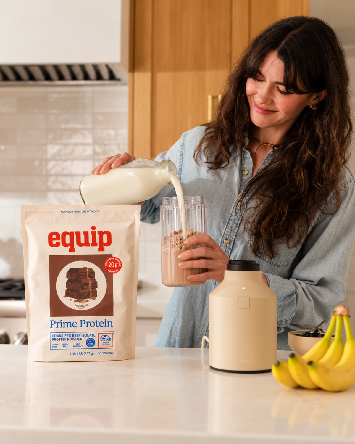 Woman pouring milk onto Prime Protein Chocolate powder to blend a shake