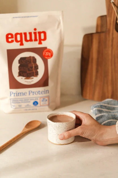 Prime Protein Chocolate pouch with a mug of chocolate protein drink